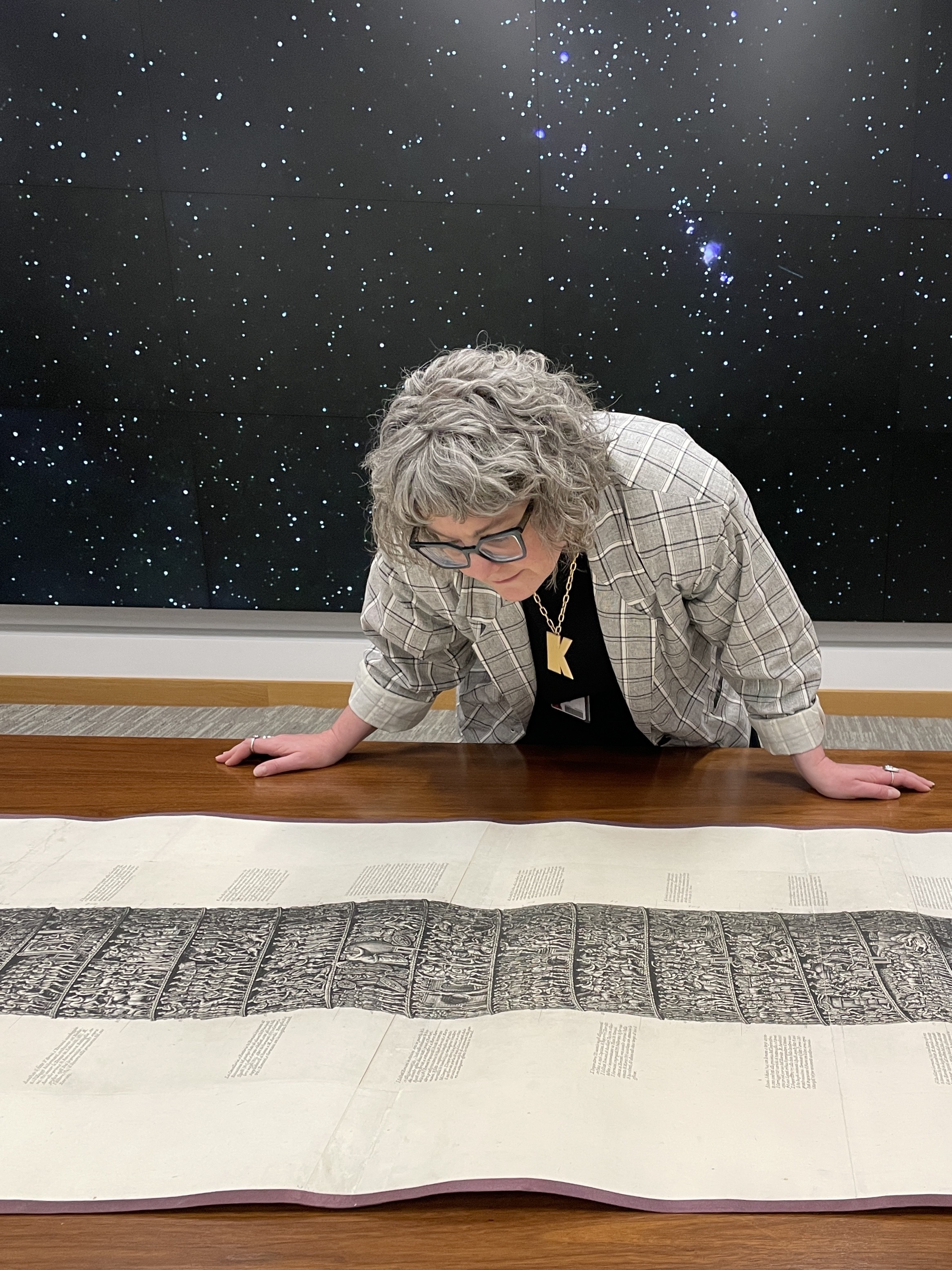 Picture of Kristina Larsen looking at a large engraving